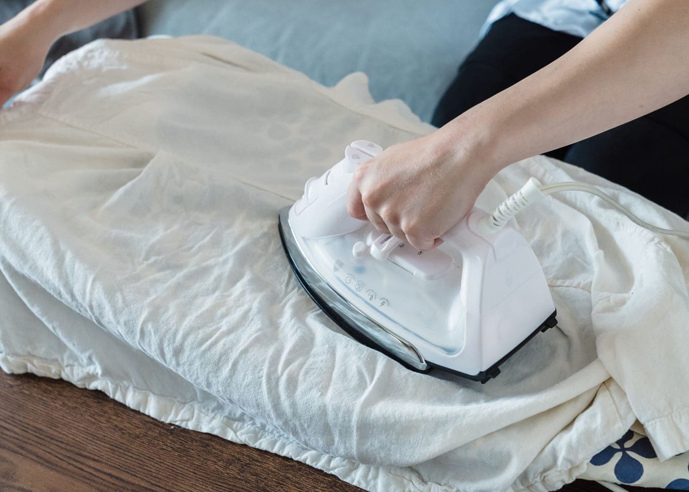 Repassage d'un drap blanc sur une planche, en tenue de travail